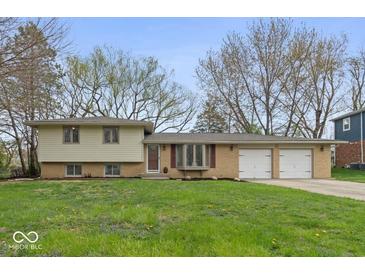 Charming ranch-style home with a well-maintained lawn and a two-car garage showcasing inviting curb appeal at 7171 N Orchard Dr, Indianapolis, IN 46236