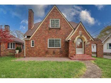 Charming brick home featuring a gabled roof, arched entry and walkway, and mature landscaping at 720 22Nd St, Columbus, IN 47201