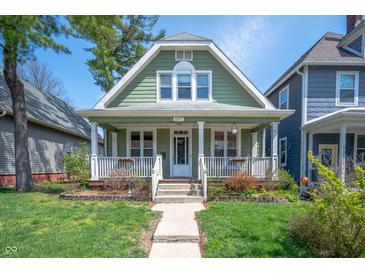Charming home with a welcoming front porch, lush landscaping, and a freshly painted exterior at 1217 Evison St, Indianapolis, IN 46203