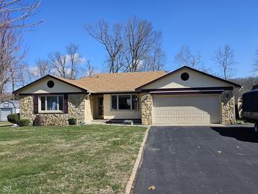 Charming ranch-style home with a stone facade, two-car garage, and well-maintained lawn at 1647 S Plateau Cir, Martinsville, IN 46151