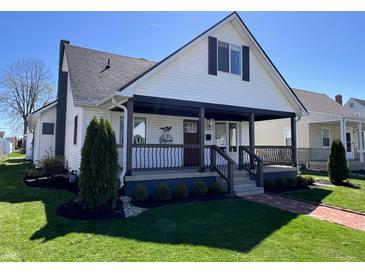 Charming two-story home featuring a covered front porch, manicured lawn and stylish black and white color palette at 2029 Winton Ave, Indianapolis, IN 46224