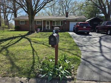 Charming single-story brick home with a well-manicured lawn and mailbox by the driveway at 3614 Thorncrest Dr, Indianapolis, IN 46234