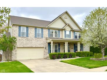 Charming two-story brick home with blue shutters, a covered porch, well-kept lawn, and attached garage at 3724 Jonathan Rdg, Columbus, IN 47201