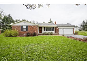 Charming brick home featuring an attached garage and a well-maintained lawn at 5555 W Vermont St, Indianapolis, IN 46224