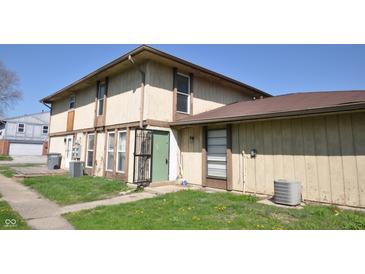 Multi-Gathering home with beige siding, green doors, and trimmed windows at 6512 Lupine Ter # 6512, Indianapolis, IN 46224