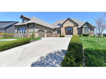 Stunning home with stone accents, a well-manicured lawn, and a spacious three-car garage at 7128 Trail Ridge Ln, Indianapolis, IN 46259