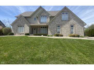 Traditional brick home with a lush green lawn and manicured landscaping in a suburban neighborhood at 1394 Cherry Tree Rd, Avon, IN 46123