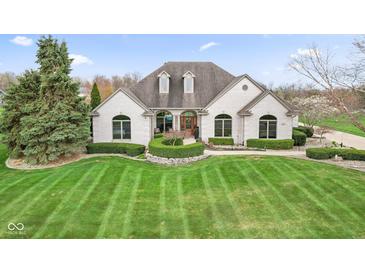 Elegant white brick home featuring arched windows and a beautifully landscaped front yard at 1583 E Osprey Dr, Greenfield, IN 46140