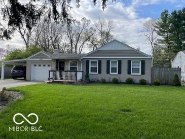 Charming single-story home featuring a manicured lawn, attached carport, and classic curb appeal at 2335 Durham Dr, Indianapolis, IN 46220