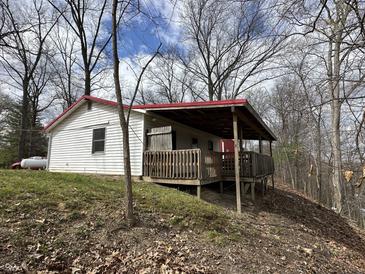Charming exterior view of a home with a covered deck, set against a backdrop of mature trees at 2975 High Rock Dr, Martinsville, IN 46151