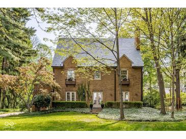 Charming two-story brick home featuring a slate roof and lush landscaping at 4151 N Pennsylvania St, Indianapolis, IN 46205
