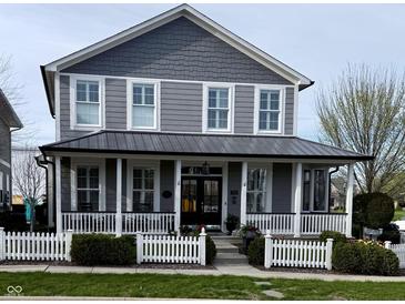 Charming two-story home with a covered front porch and white picket fence at 7638 Beekman Ter, Zionsville, IN 46077
