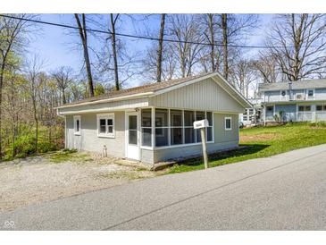Charming home with grey siding, screened porch, and mature trees at 8644 S Kinman Dr, , IN 46164