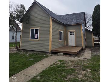 A charming home exterior showcases a new gray roof and light green siding at 1016 Dawson St, Indianapolis, IN 46203