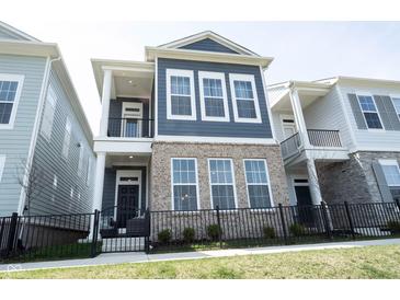 Stately home with a covered porch, brick accents, and a well-manicured lawn at 1099 Valentine Ln, Carmel, IN 46032