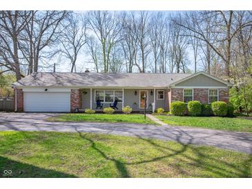 Charming single story home featuring a brick accent, inviting front porch, and manicured lawn at 1109 Oakwood Trl, Indianapolis, IN 46260