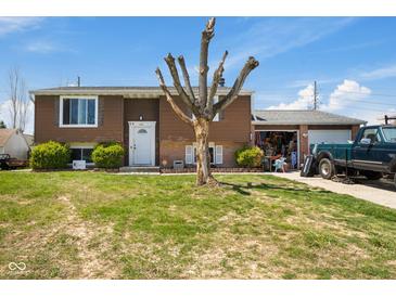 Split-level home featuring brown siding, an attached garage and a lawn at 1206 Rosengarten Dr, Greenwood, IN 46142