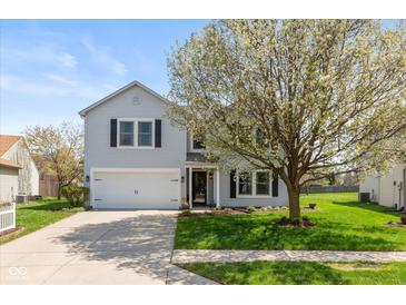 Charming two-story home with a well-manicured lawn and mature tree at 14195 Holly Berry Cir, Fishers, IN 46038