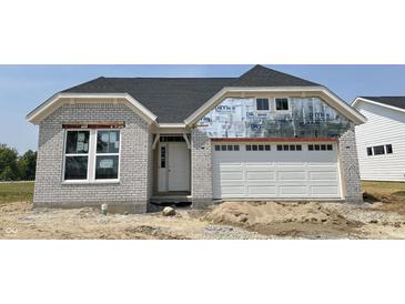 New construction home showing a gray brick exterior, white garage door, and dark grey roof at 14910 Garden Mist Pl, Fishers, IN 46037