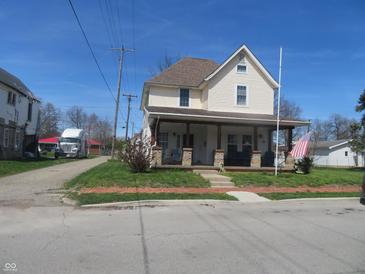 Charming two-story home featuring a cozy front porch and well-maintained front yard at 210 E Monroe St, Alexandria, IN 46001