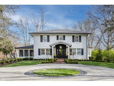 Charming white brick home with a circular driveway and manicured lawn at 222 E 71St St, Indianapolis, IN 46220