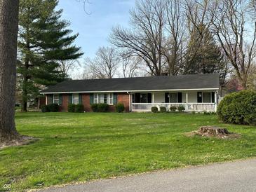 Charming ranch home features a brick exterior, white porch, green shutters, and a well-maintained lawn at 4290 Manning Rd, Indianapolis, IN 46228