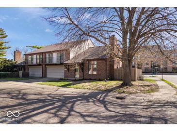 Charming brick home featuring balconies, a two-car garage, and mature trees in a residential neighborhood at 456 E Arch St, Indianapolis, IN 46202