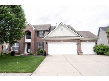 Charming two-story brick home with a three-car garage, manicured lawn, and tasteful landscaping at 8748 N Autumnview Dr, McCordsville, IN 46055