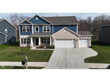 Charming two-story home with a brick and blue facade and a well-manicured lawn at 9207 Foudray N Cir, Avon, IN 46123