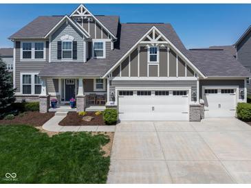 Inviting two-story home with a gray facade, manicured lawn, and a spacious driveway leading to a two-car garage at 11014 Woodpark Dr, Noblesville, IN 46060