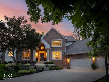 Stunning brick home featuring a landscaped front yard and attached three-car garage at 12304 Ridgeside Rd, Indianapolis, IN 46256