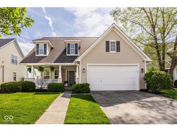 Charming two-story home featuring a covered porch, manicured lawn, and a two-car garage at 15037 Rutherford Dr, Westfield, IN 46074