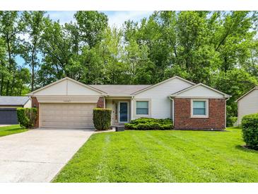 Charming single-story home with a well-manicured lawn and attached two-car garage at 1697 Stacy Lynn Dr, Indianapolis, IN 46231