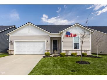 Charming one-story home with a manicured lawn, attached garage, and American flag, exuding curb appeal at 2548 Ruffian Dr, Westfield, IN 46074