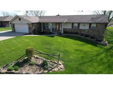 Charming single-story home featuring a well-manicured lawn and stone accents at 5210 S 100 E Rd, Anderson, IN 46013
