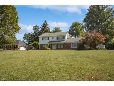 Charming two-story home featuring a combination of brick and white siding with a well-maintained lawn and mature trees at 5363 Channing Rd, Indianapolis, IN 46226
