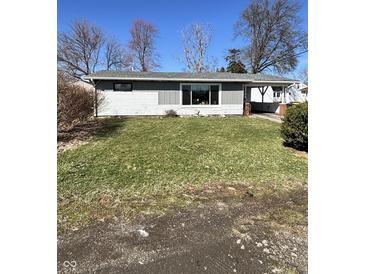 A single-story home featuring light grey siding, large front window, and a well-maintained lawn in a residential neighborhood at 1618 E 24Th St, Muncie, IN 47302