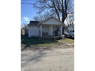 Charming single-story home with a cozy front porch and a well-maintained lawn under a sunny sky at 1619 E 20Th St, Muncie, IN 47302