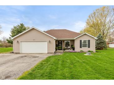 Charming single-story home with manicured lawn, attached garage, and inviting curb appeal at 204 S Hougland St, Trafalgar, IN 46181