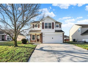 Charming two-story home featuring a manicured lawn and an attached two-car garage at 209 Allen Ln, New Whiteland, IN 46184