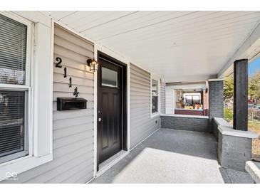 Charming front porch with gray siding, black door, and mailbox, perfect for enjoying the outdoors at 2114 N Dexter St, Indianapolis, IN 46202