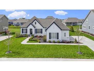 Stunning single-Gathering home with a white brick exterior, dark shutters, a gray roof and a perfectly manicured front lawn at 3840 Shady Lake Dr, Westfield, IN 46074