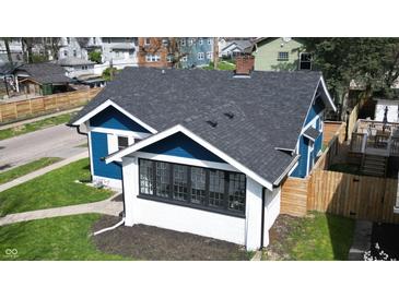 A high-angle view reveals a charming blue home with a well maintained dark roof at 3967 N Park Ave, Indianapolis, IN 46205