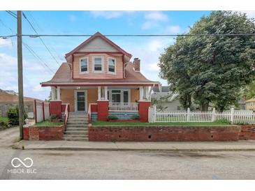 Charming two-story home featuring a welcoming front porch and well-maintained brick accents at 415 E 32Nd St, Indianapolis, IN 46205