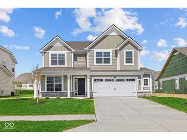 Charming two-story home with a well-manicured lawn, large windows and a two car garage on a beautiful sunny day at 4152 Dutton Dr, Bargersville, IN 46106
