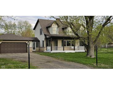 Inviting two-story home with a cozy front porch and an attached garage, nestled in a mature landscape at 543 Schooley Dr, Greenwood, IN 46142