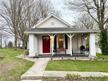 Charming home featuring a brick foundation, red front door, and a cozy front porch at 5845 South St, Stilesville, IN 46180