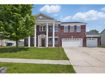 Stately brick home featuring a grand facade with prominent columns and a well-maintained lawn at 621 Fireside Dr, Greenwood, IN 46143