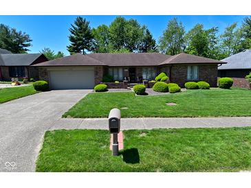 Charming brick ranch-style home with lush landscaping and a well-maintained lawn at 6318 Dahlia Dr, Indianapolis, IN 46217