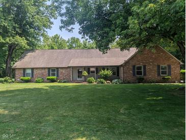 Charming single-story brick home featuring lush green lawn and mature trees at 8017 Dogwood Ct, Plainfield, IN 46168